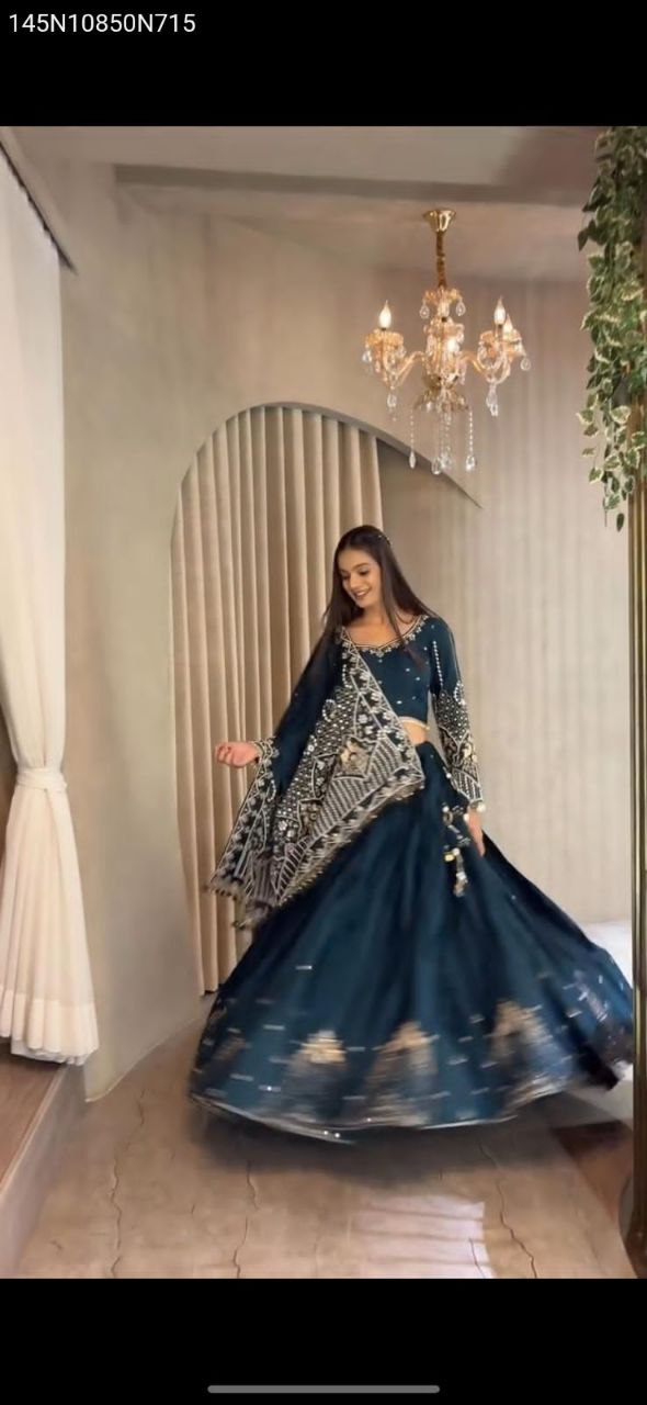 TRENDBUY model elegantly posing in a teal blue heavy embroidery crepe silk lehenga choli with dupatta, showcasing the full ensemble.