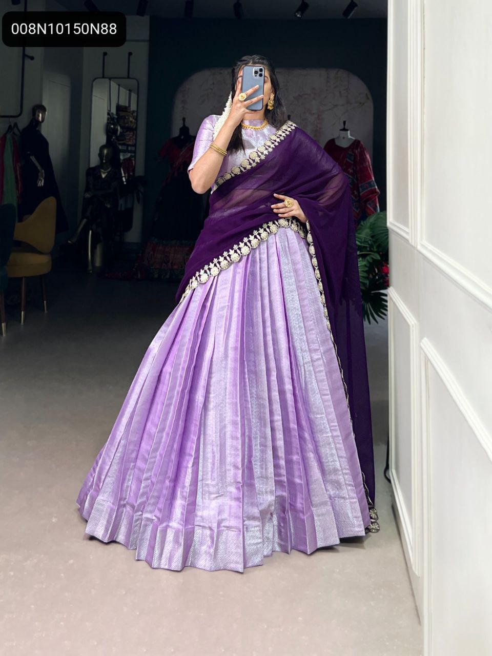 TRENDBUY lavender and deep purple Jacquard silk lehenga choli with sequin-embroidered dupatta, model posing front-facing in a boutique.