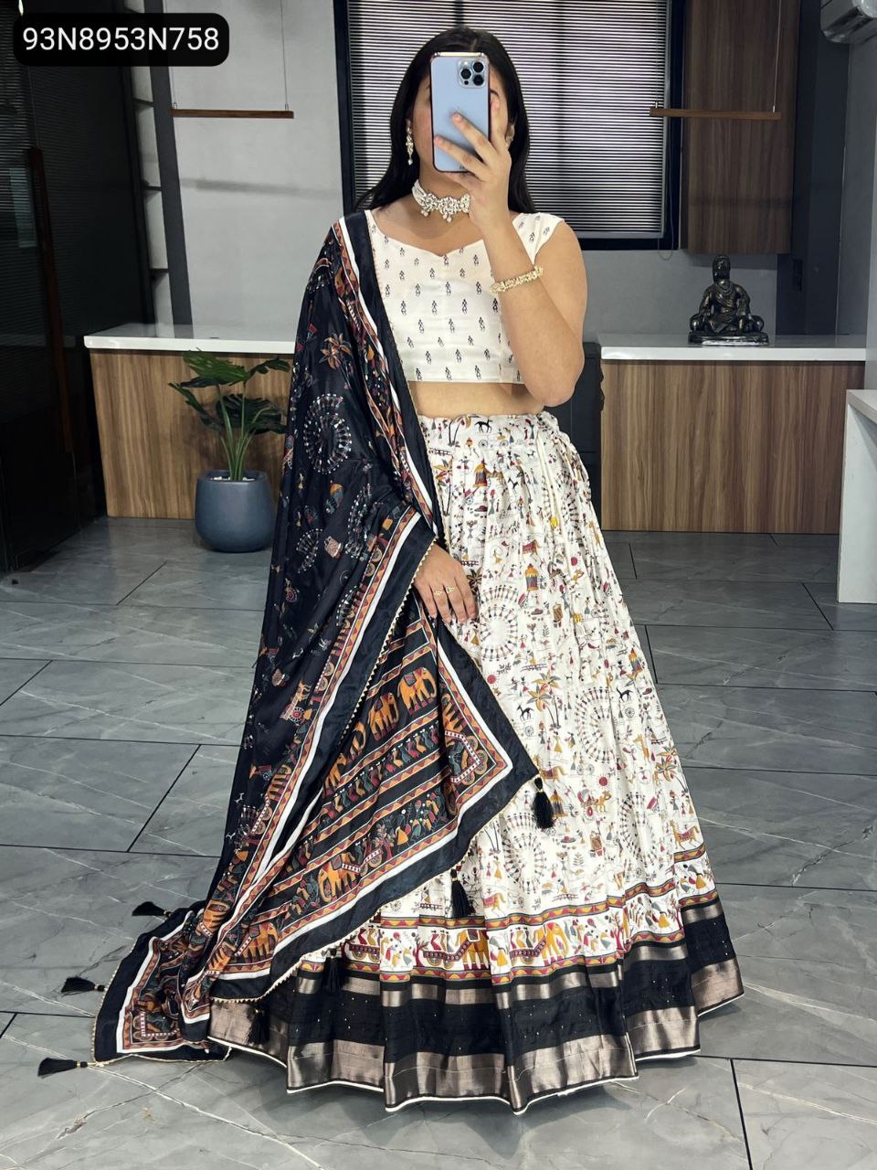 Elegant woman posing in a TRENDBUY white and black Kalamkari Dola Silk lehenga with matching black border and black printed Chinon dupatta.