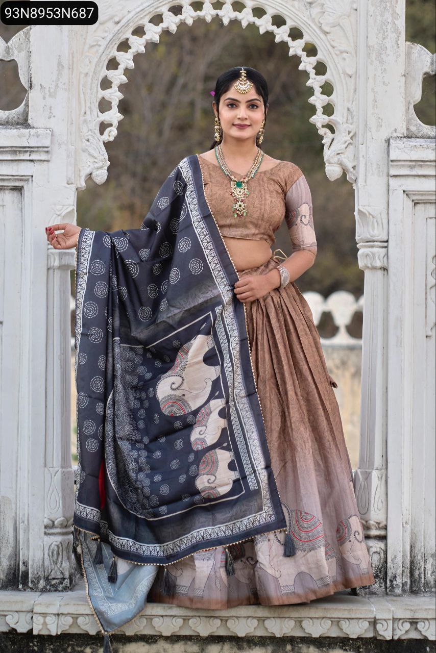 Full body shot of a model in the TRENDBUY Kalamkari Manipuri silk lehenga choli, showcasing the brown lehenga skirt and dark blue dupatta, posing elegantly in a white architectural archway.