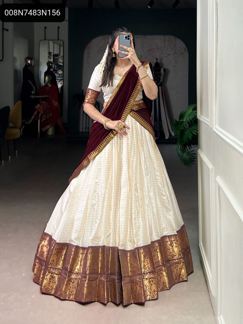 Full body shot of a model wearing a TRENDBUY Kalyani Poly Cotton lehenga choli with a cream chex pattern, a maroon georgette dupatta, and intricate zari weaving borders, showcasing traditional Indian attire.