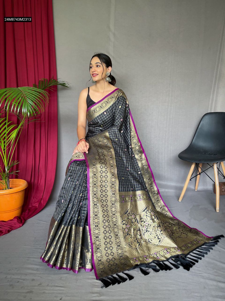 Model wearing TRENDBUY Black Kanjeevaram Silk Saree with gold jacquard border and subtle meena motifs, sitting gracefully.