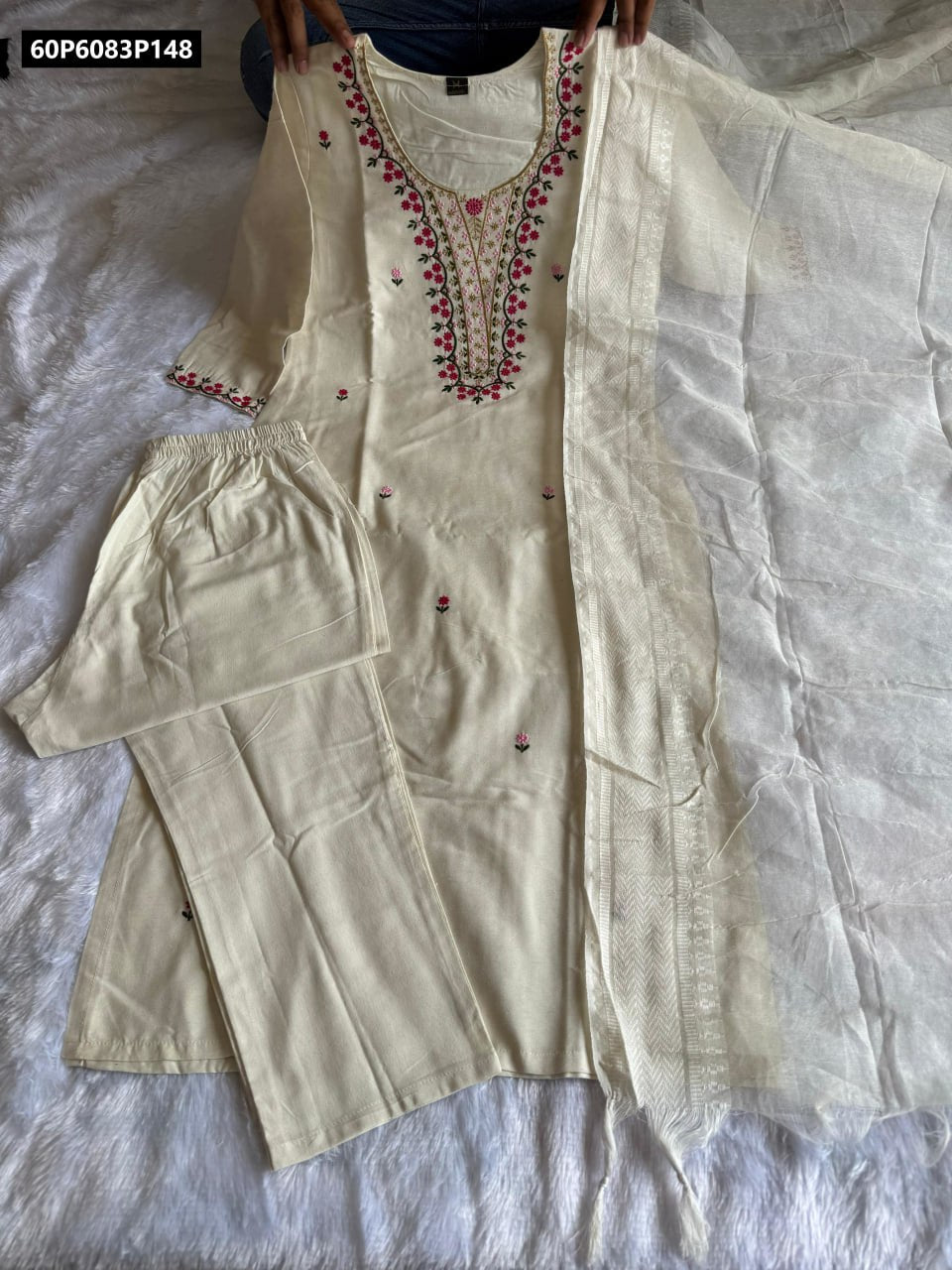 Full set of TRENDBUY white khadi cotton embroidered kurti, pant, and zig-zag border dupatta, held by hands for a clear display.