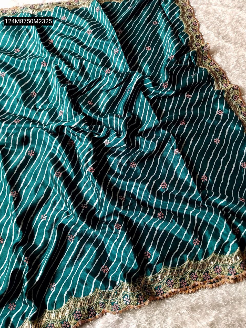 TRENDBUY Green Chinnon leheriya saree with white stripes and pink floral motifs, featuring an intricate gold sequin embroidery border spread on a white textured surface.