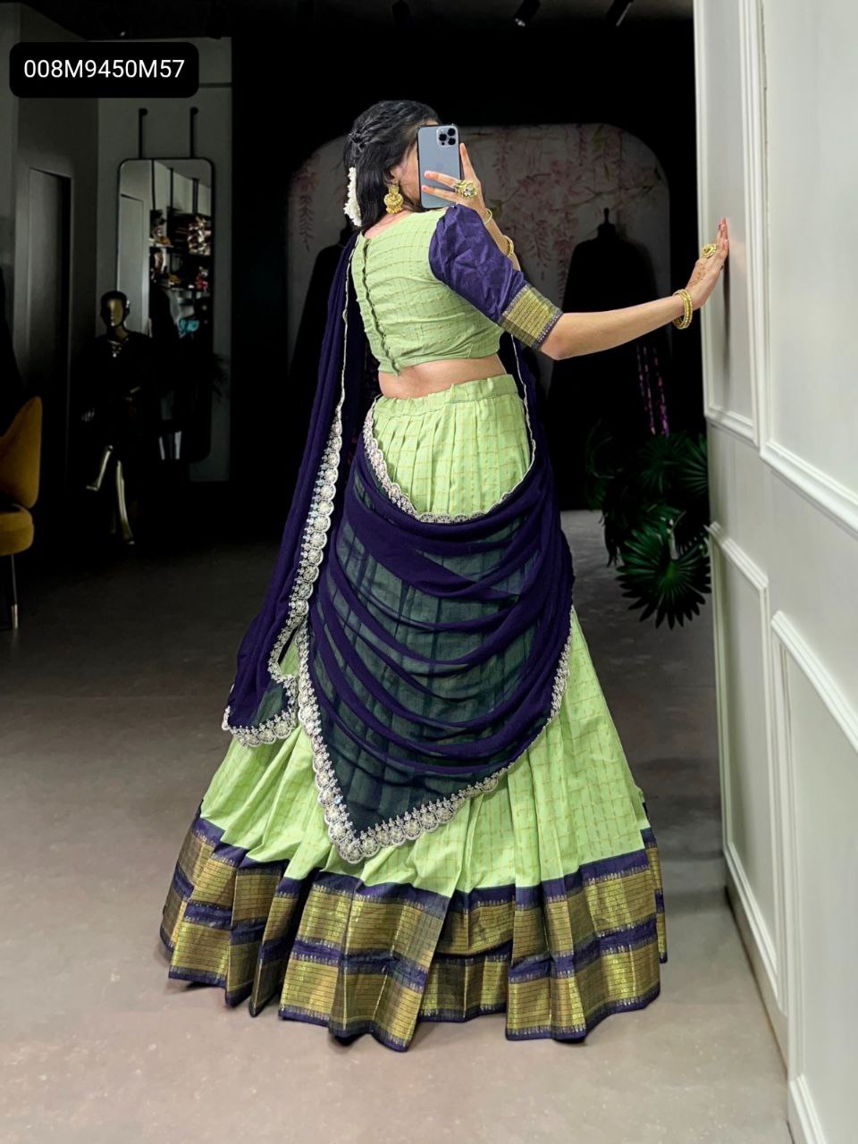 TRENDBUY Lime Green and Purple Lehenga Choli back view, featuring intricate zari weaving on the skirt, a broad gold and purple border, and an elegantly draped sequined georgette dupatta. Ideal for celebratory occasions.