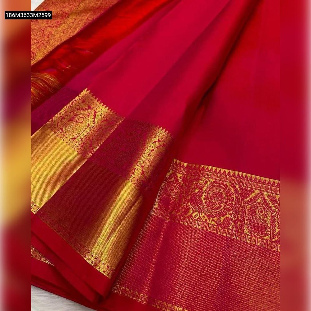 Close-up of a vibrant Rani Pink Banarasi soft silk saree border with intricate gold zari traditional motifs.