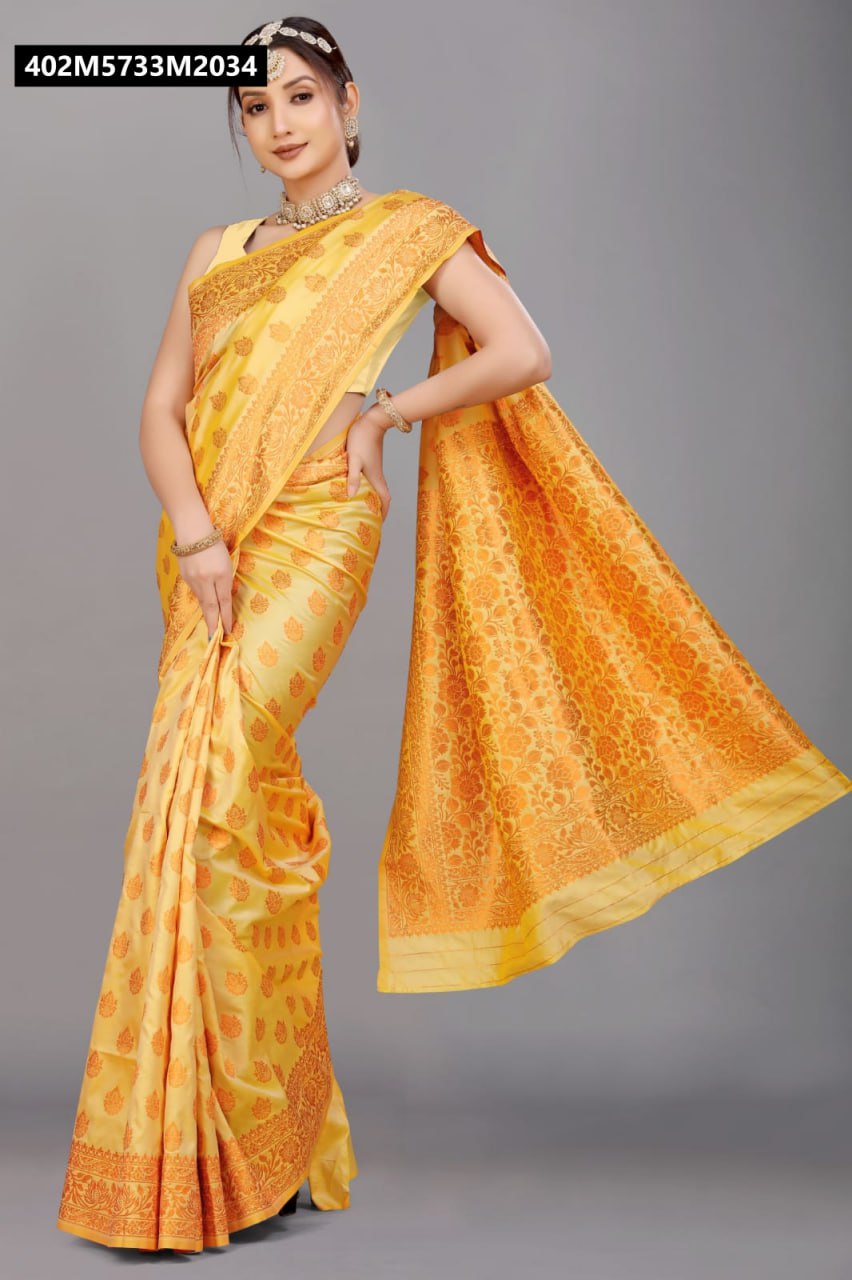 Model posing in a radiant yellow soft silk saree with intricate copper zari floral patterns and traditional jewelry.