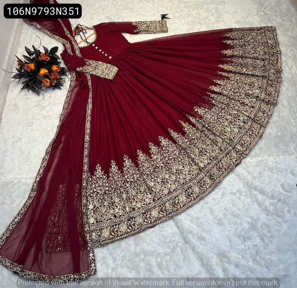 TRENDBUY Maroon Fox Georgette Gown with full 4-meter flare and matching embroidered dupatta, elegantly laid out on a white textured surface with a floral bouquet.