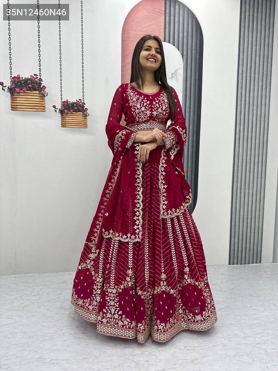 Full body shot of a smiling model wearing a maroon TRENDBUY Fox Georgette Lehenga Choli with heavy 7mm sequence embroidery, looking directly at the camera.
