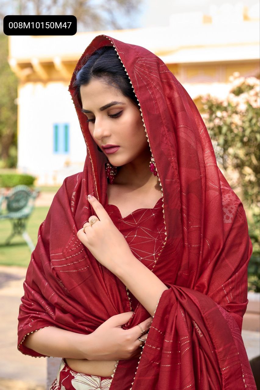 Close-up of a woman in a maroon Tussar silk dupatta, embellished with subtle gold foil print and a scalloped border, styled with traditional earrings and rings.