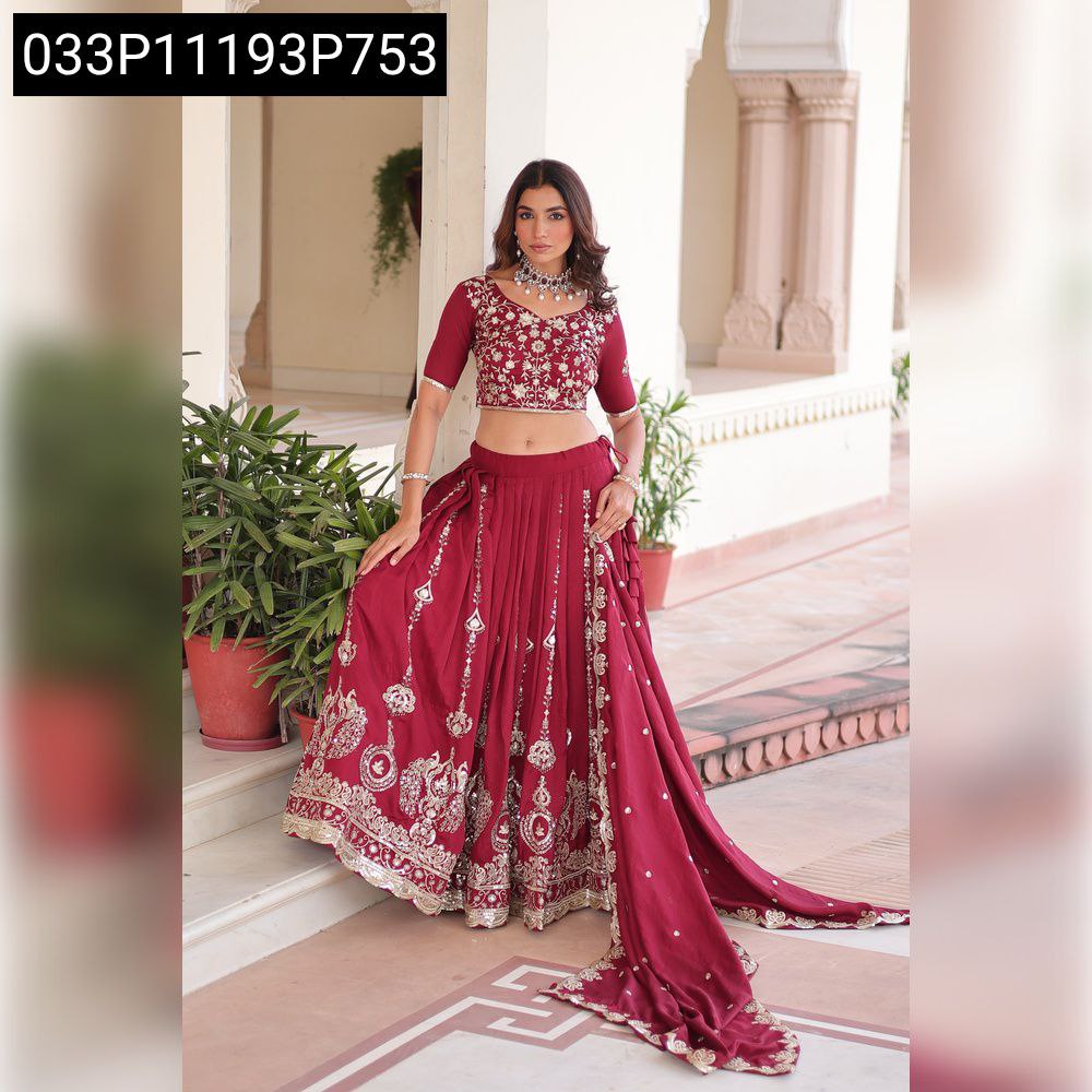 Close-up of intricate gold thread embroidery and heavy sequins on maroon silk fabric