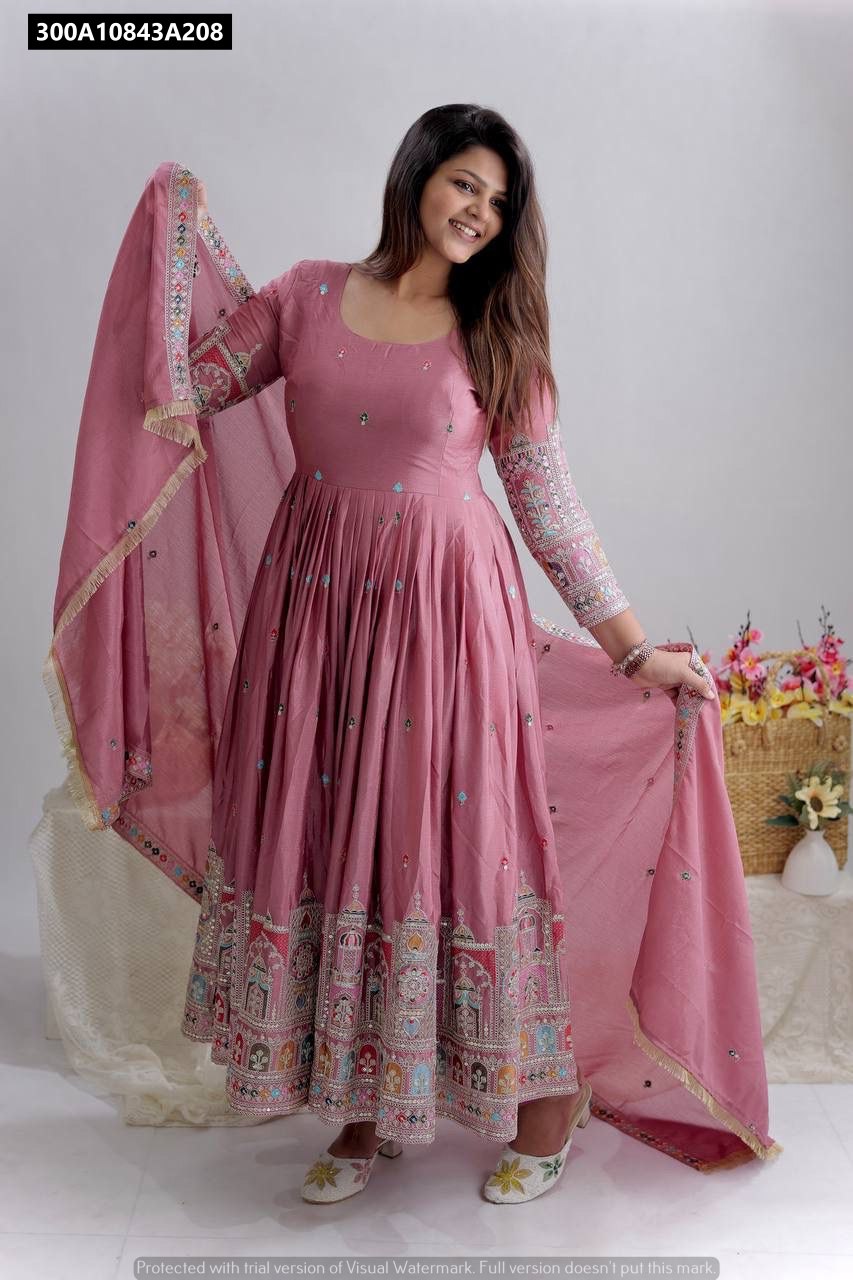 Full body model shot of a woman smiling, wearing the Mauve Pink Cinon Silk Anarkali Gown with heavy embroidery and holding the matching dupatta.
