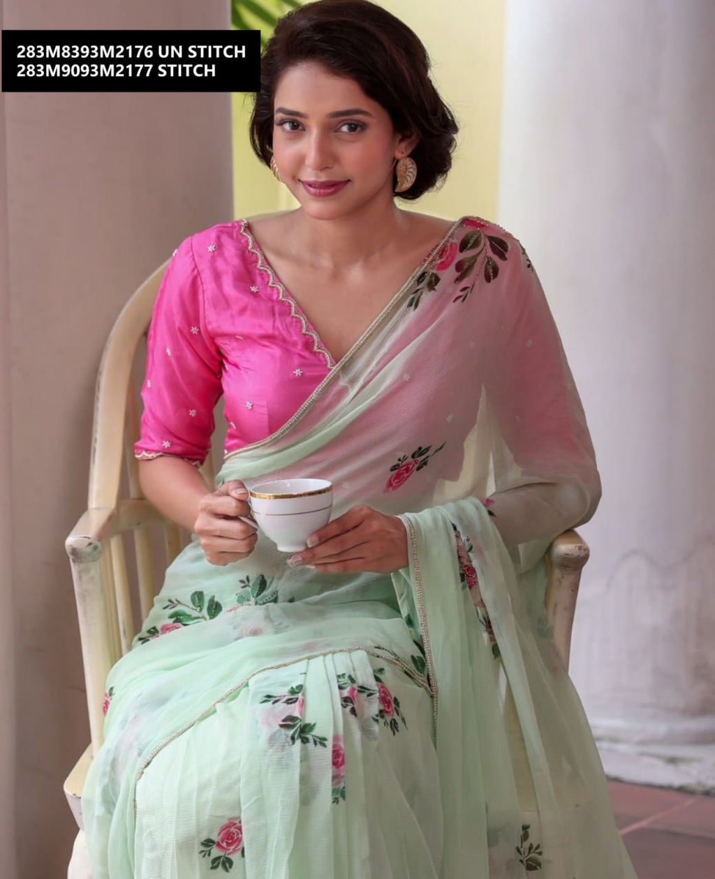 Model seated, holding a teacup, showcasing the delicate drape and floral print of the TRENDBUY georgette saree.