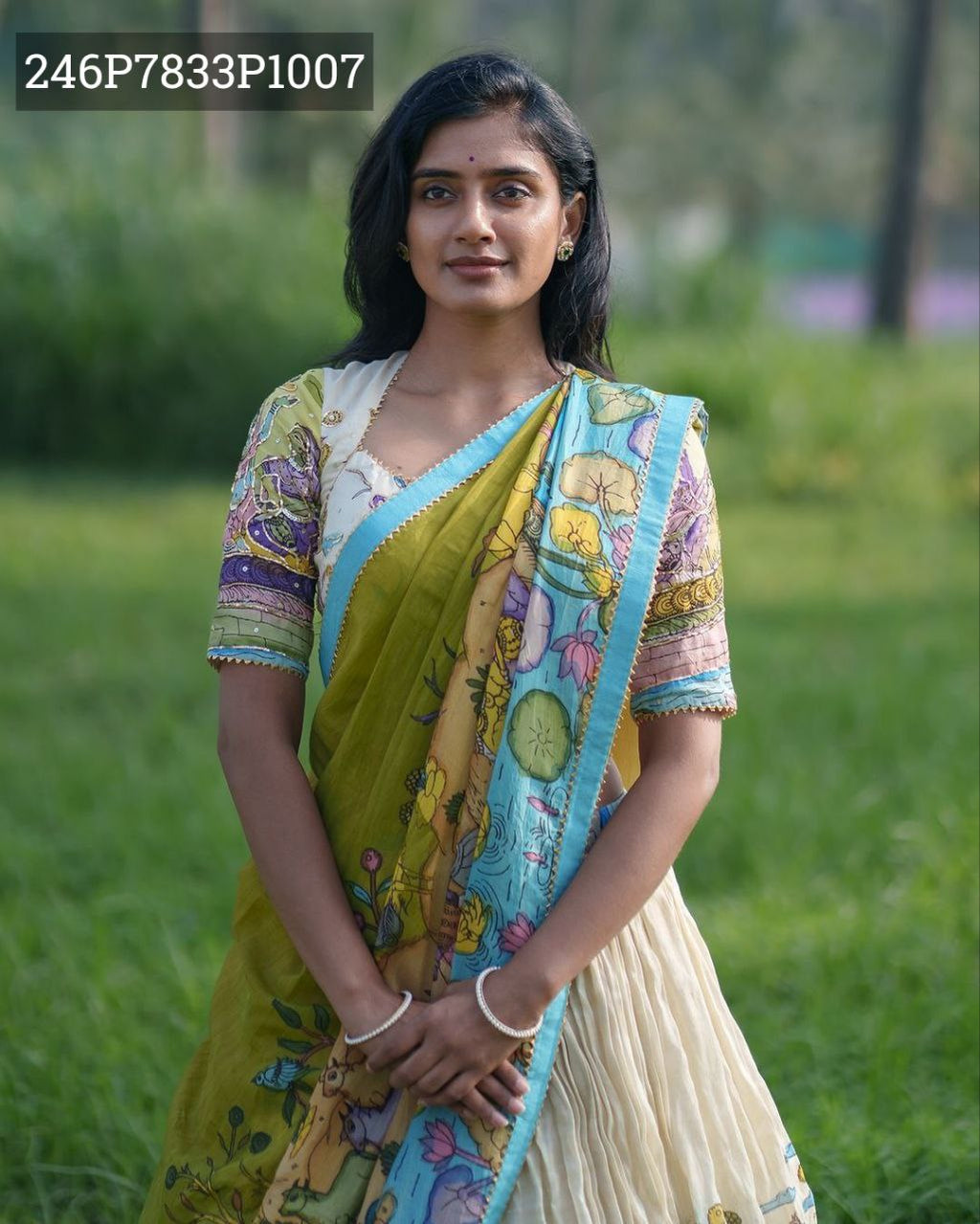 Model wearing TRENDBUY Off-White Base Kalamkari Print Tussar Silk Lehenga Choli Set, standing outdoors in a grassy field.