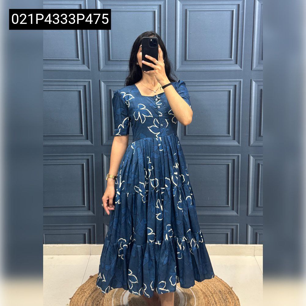 Model wearing a Deep Blue muslin cotton tiered dress with white abstract floral print, full body shot.