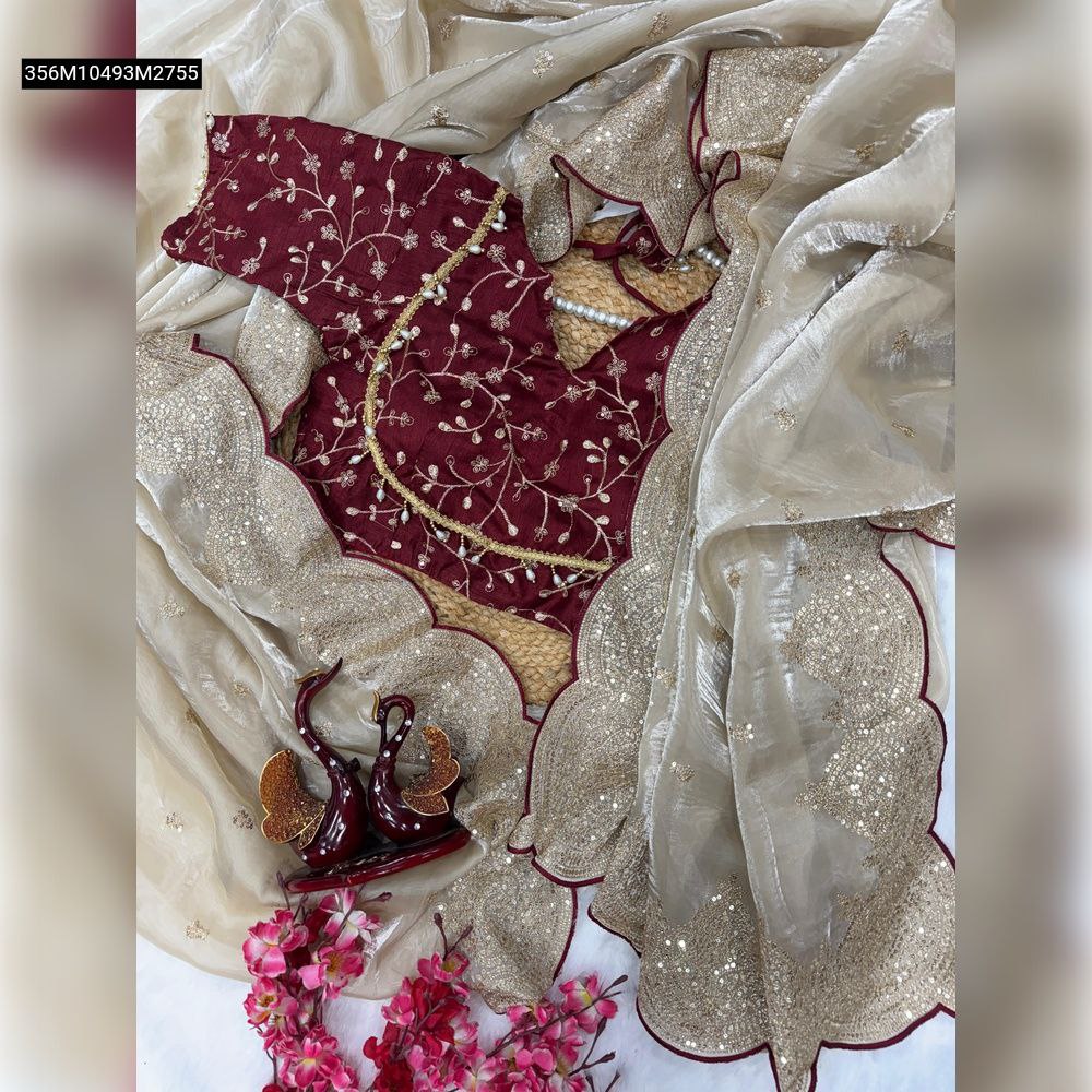 Overhead flat lay of TRENDBUY muted champagne gold Jimmy Chu saree with scalloped sequin-zari embroidered border, draped with a maroon Banglori silk blouse featuring intricate floral zari embroidery.