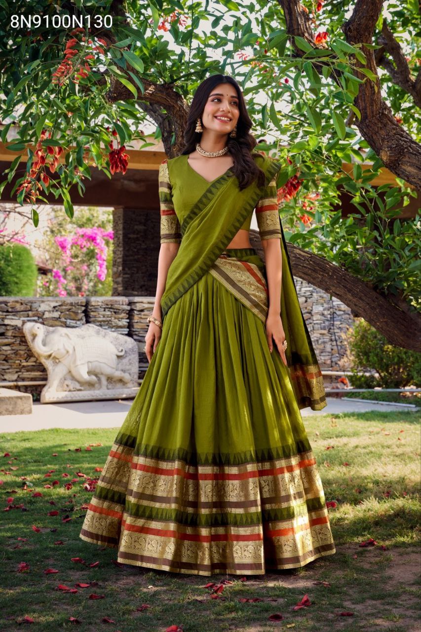 Front view of model in TRENDBUY Nirupa Olive Green Chanderi Lehenga Choli with Zari weaving border, standing elegantly in a garden.
