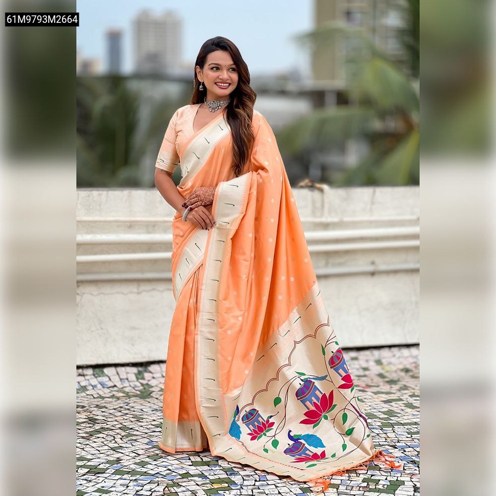 Model smiling, draped in a beautiful peach TRENDBUY Paithani silk saree with silver zari work and a vibrant multi-color meenakari peacock pallu on a rooftop.
