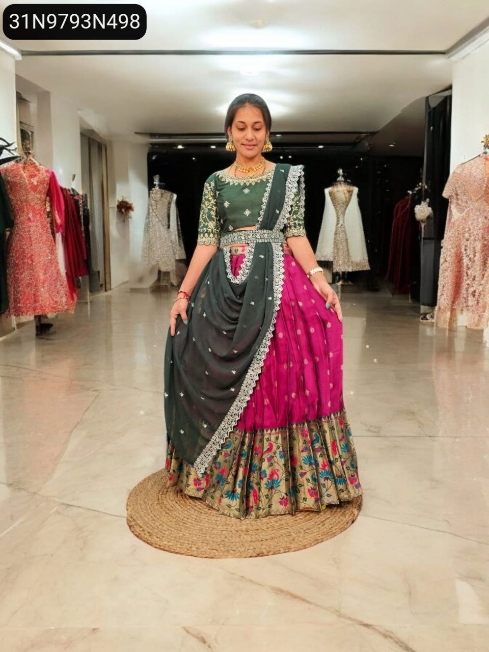 Model in TRENDBUY Paithani half saree lehenga with green blouse, magenta skirt, dark green dupatta and belt, front view in boutique