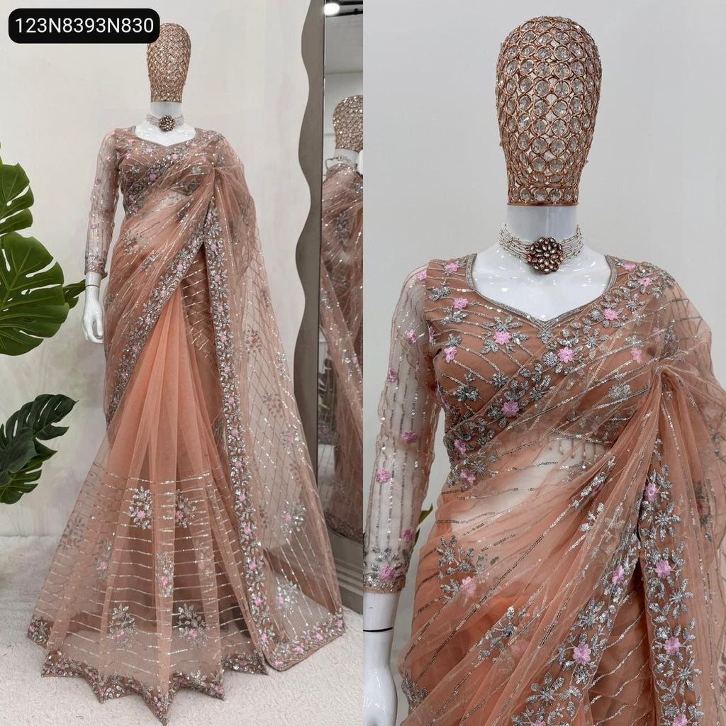 Full front view of a TRENDBUY peach-pink soft net designer saree with intricate silver thread and pink sequin floral embroidery, elegantly draped on a mannequin, showcasing the full sleeves blouse and graceful pleats.