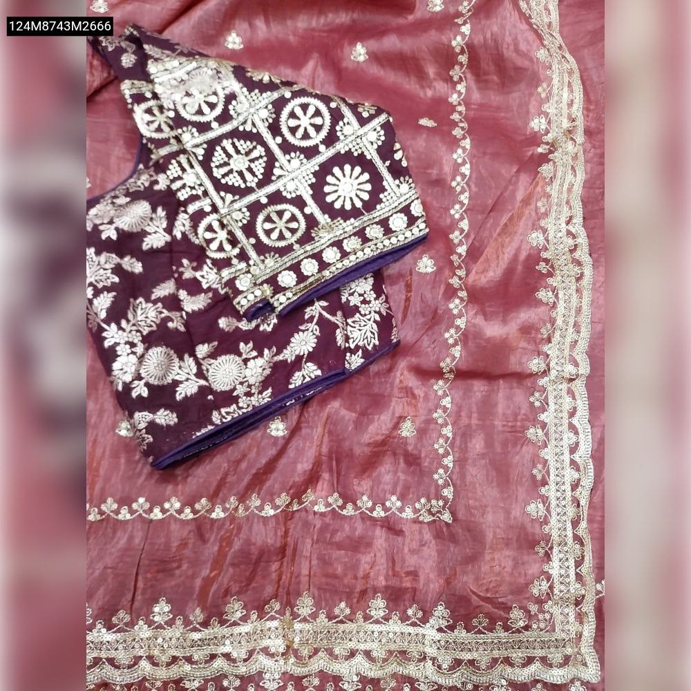 Close-up of the maroon tissue saree, highlighting the intricate gold sequin and embroidery work on its aarco border and fabric texture.