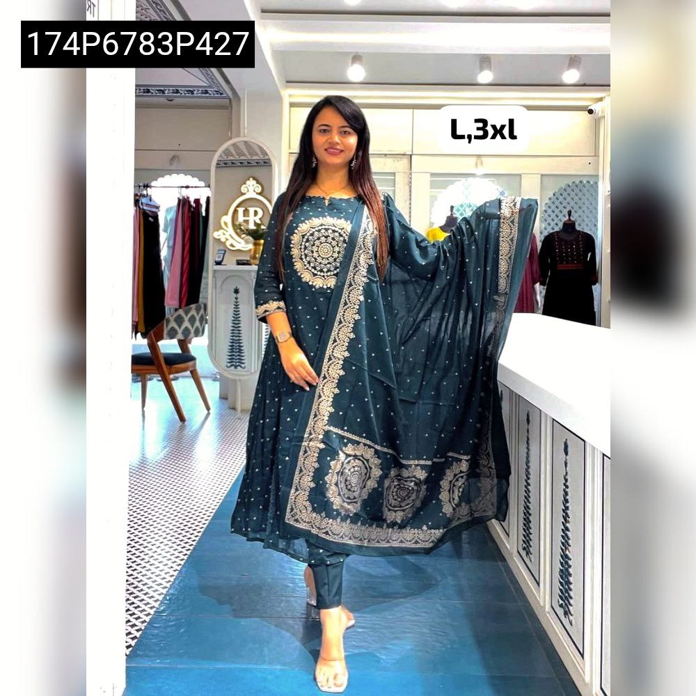 A smiling model confidently poses in a Deep Sea Green A-line kurti with an embroidered yoke, matching pants, and a flowing dupatta.