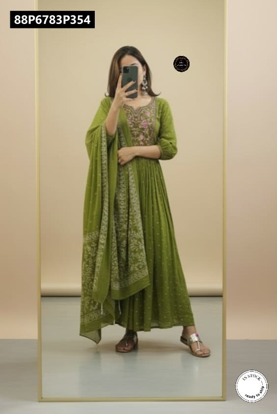 TRENDBUY model posing in a mirror, displaying the full length of the green Anarkali kurti set with embroidered details and elegantly draped malmal cotton dupatta.