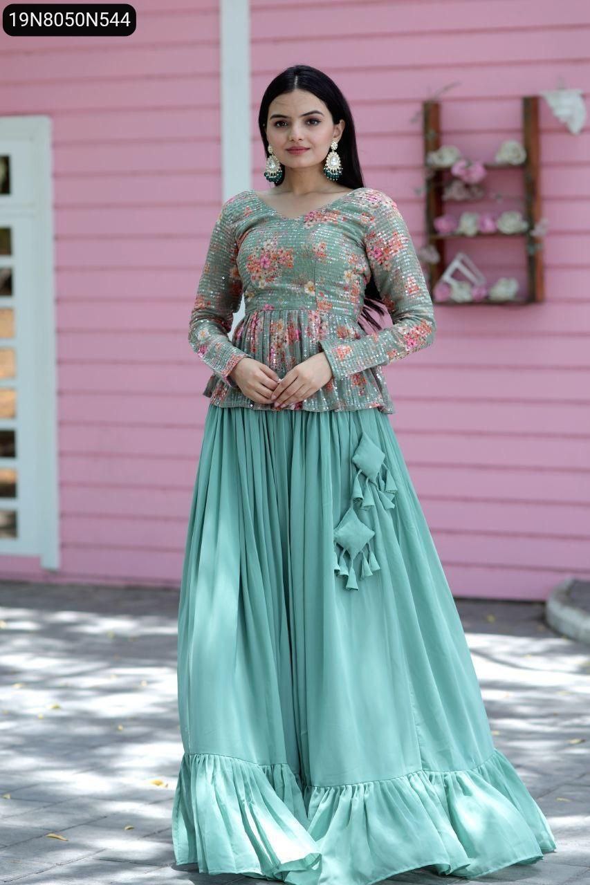 Elegant model standing gracefully in the TRENDBUY Seafoam Green Designer Lehenga Choli Set, showcasing the full-flared lehenga with frills and the sequined floral peplum top against a pink backdrop.
