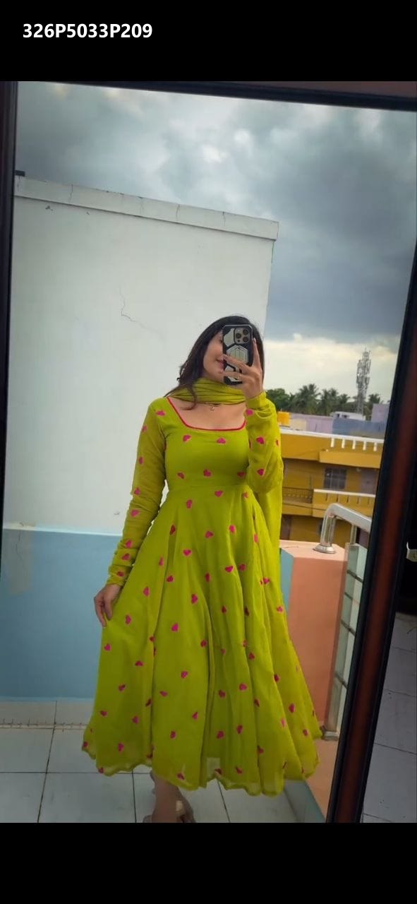 Model in a vibrant green TRENDBUY Valentina Anarkali gown with pink heart embroidery, posing for a mirror selfie.