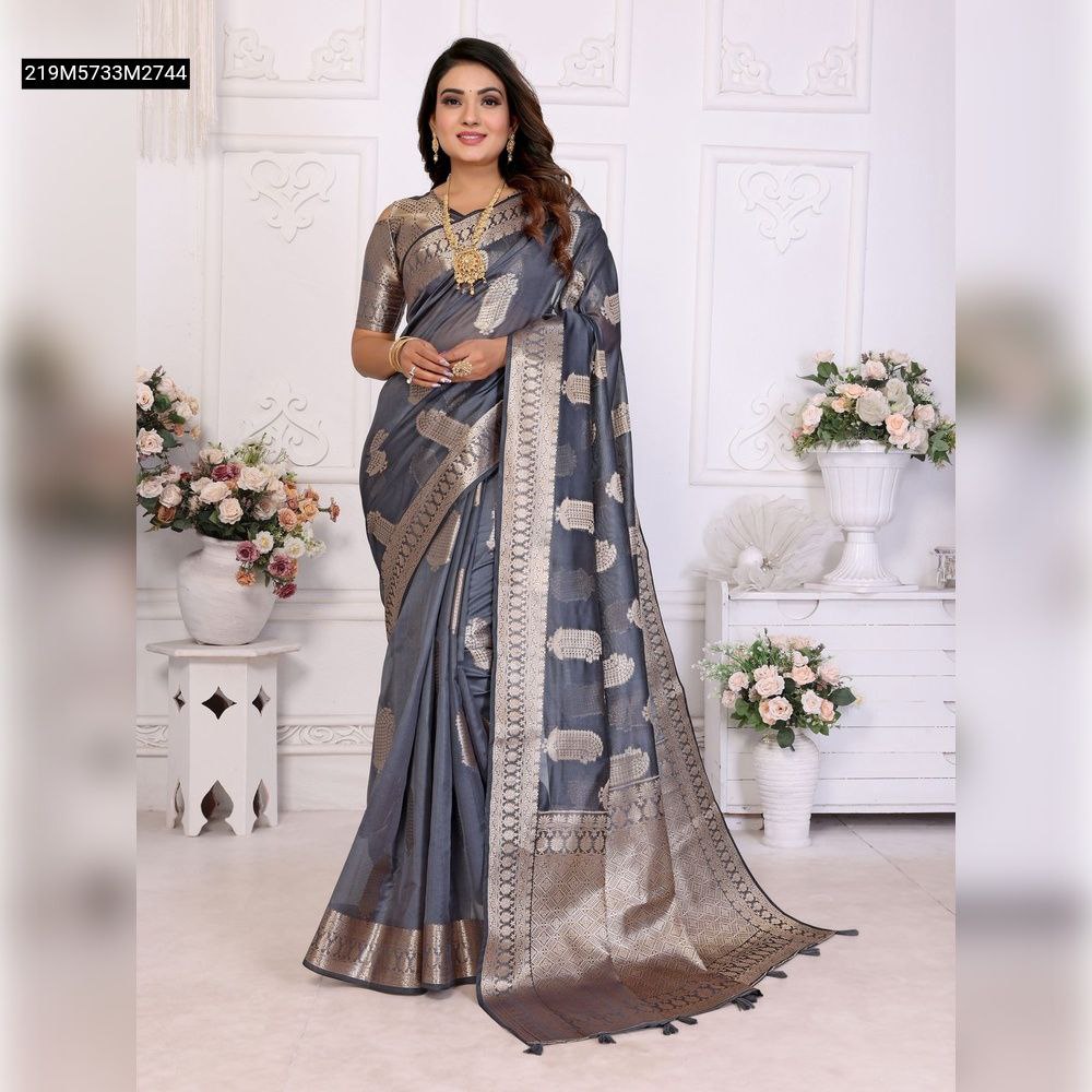 Model wearing a TRENDBUY Grey Organza Silk Banarasi Saree with gold zari butta and rich pallu, posed elegantly in a white room.