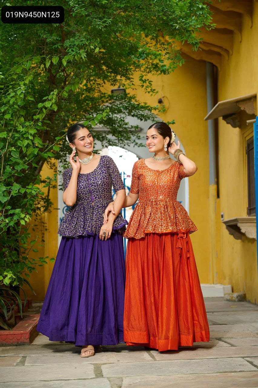 Two models in TRENDBUY sequined peplum lehenga choli sets, one in purple and one in orange, posing together in a vibrant outdoor setting.
