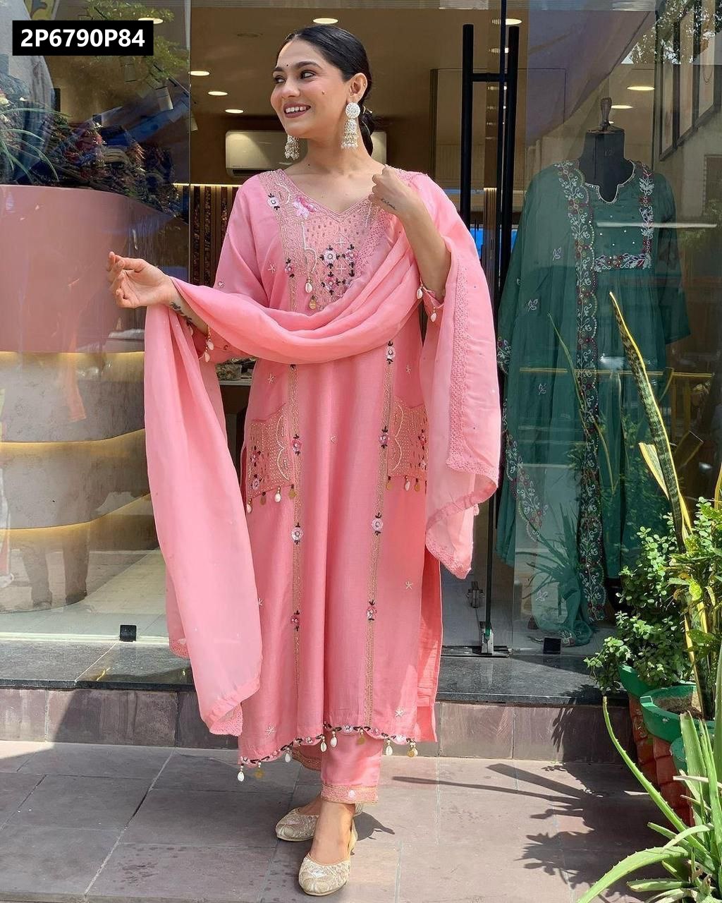 Full body shot of a woman presenting the TRENDBUY Peach Pink Roman Silk embroidered kurta set, holding the dupatta, with stylish juttis.