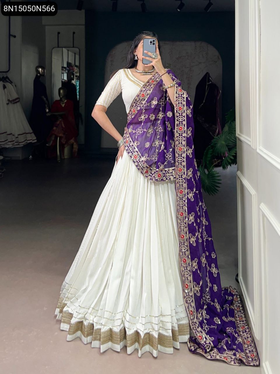 Model in pure white rayon lehenga with golden lace hem and purple sequins embroidered georgette dupatta, posing gracefully.