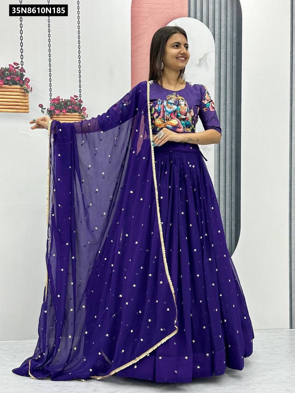 Full body shot of a smiling model elegantly posing in the TRENDBUY purple Kalamkari print lehenga choli, featuring a detailed Radha Krishna blouse, a voluminous sequence-embellished skirt, and a matching dupatta.