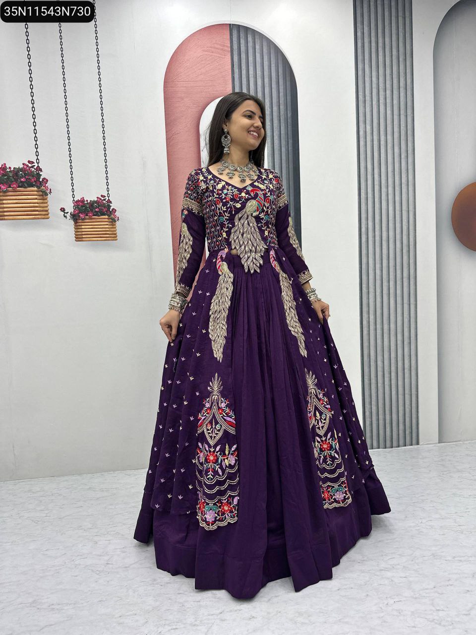 Full body shot of a smiling model wearing a purple embroidered lehenga choli with shrug and oxidized silver jewelry.