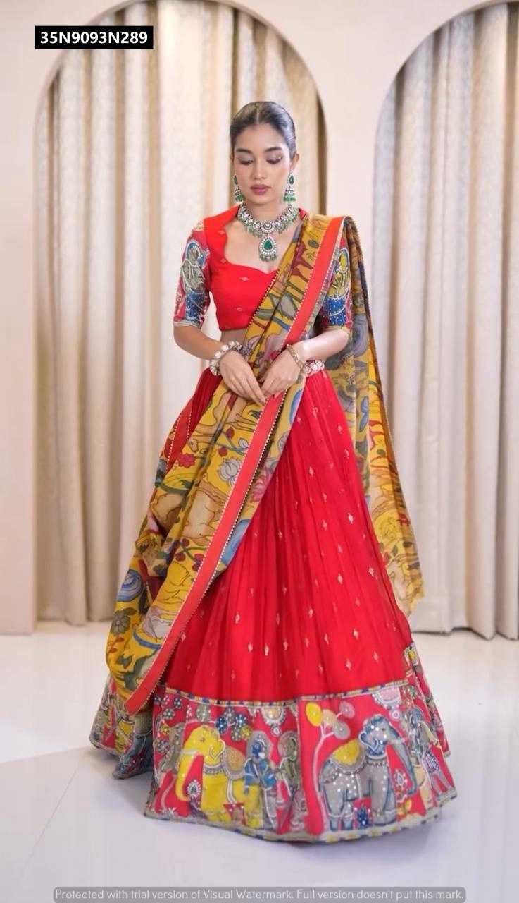 Full-length front view of the model gracefully posing in the TRENDBUY red Kalamkari lehenga choli set, accessorized with striking emerald green jewelry.