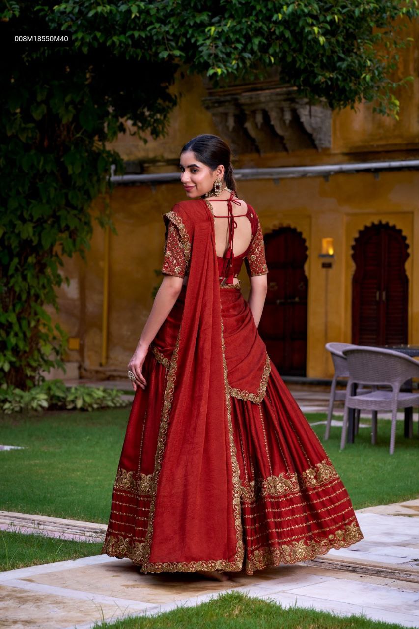 TRENDBUY model showcasing the back view of a regal rust orange Rangoli Silk lehenga choli with elaborate gold embroidery and a draped dupatta in an outdoor setting.