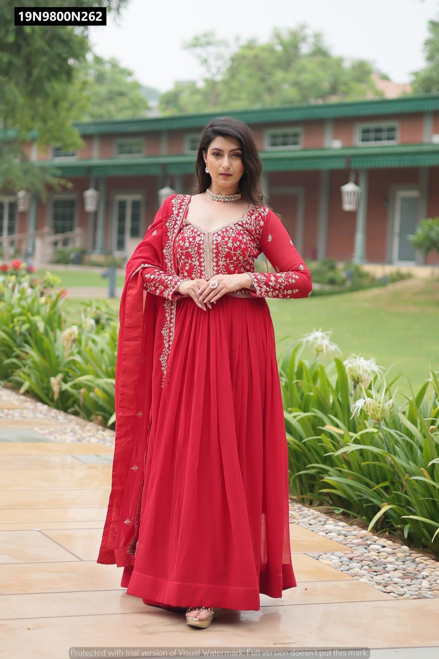 A captivating model standing in a gorgeous maroon sequin embroidered anarkali gown with a matching dupatta, exuding elegance in an outdoor setting.