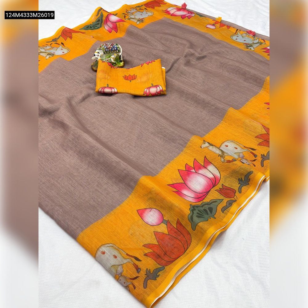 Full flat lay of TRENDBUY Soft Linen Saree with light brown body, vibrant yellow border, and a matching blouse piece, adorned with distinctive lotus and cow motifs.