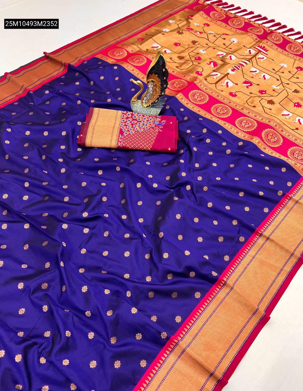 TRENDBUY Royal Blue Pethani Silk Saree with golden buttis, intricate zari weaving, and a contrasting pink and gold Meenakari peacock pallu and border, laid out with a matching blouse.