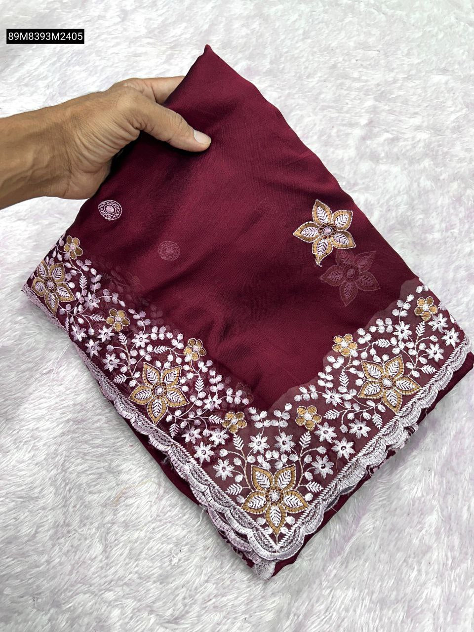 TRENDBUY Soft Rangoli Silk Saree in Maroon, folded neatly, showcasing intricate white and gold floral sequence embroidery on a cutwork border.