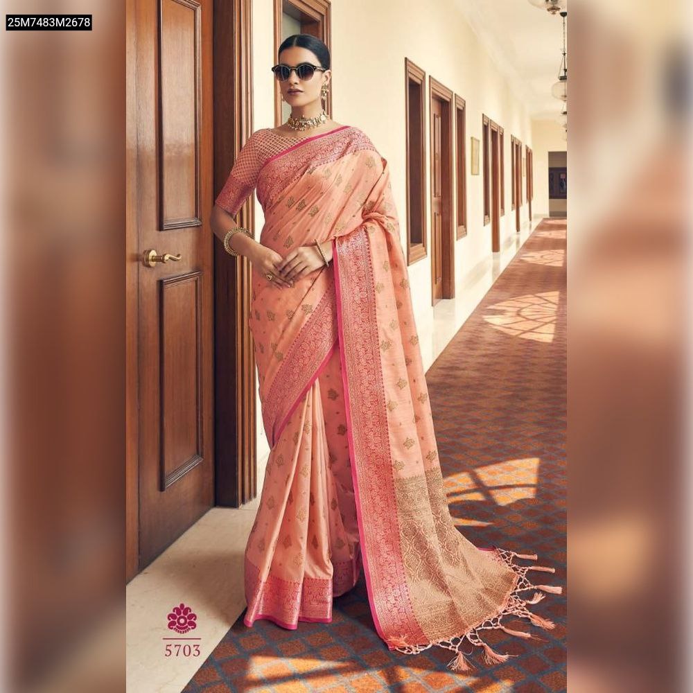 Elegant model showcasing a TRENDBUY Peach soft silk saree with all-over gold zari motifs, a luxurious rich pallu, and a matching pink zari woven border.
