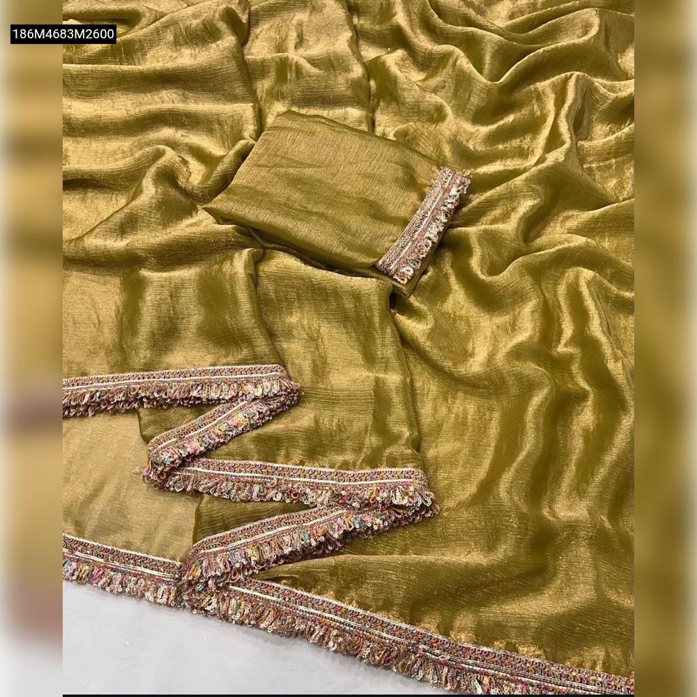 Close-up overhead shot of an unfolded olive gold Chiffon Fendy saree showcasing its shimmery texture and elaborate golden lace border with small colorful embellishments, with a matching blouse piece.