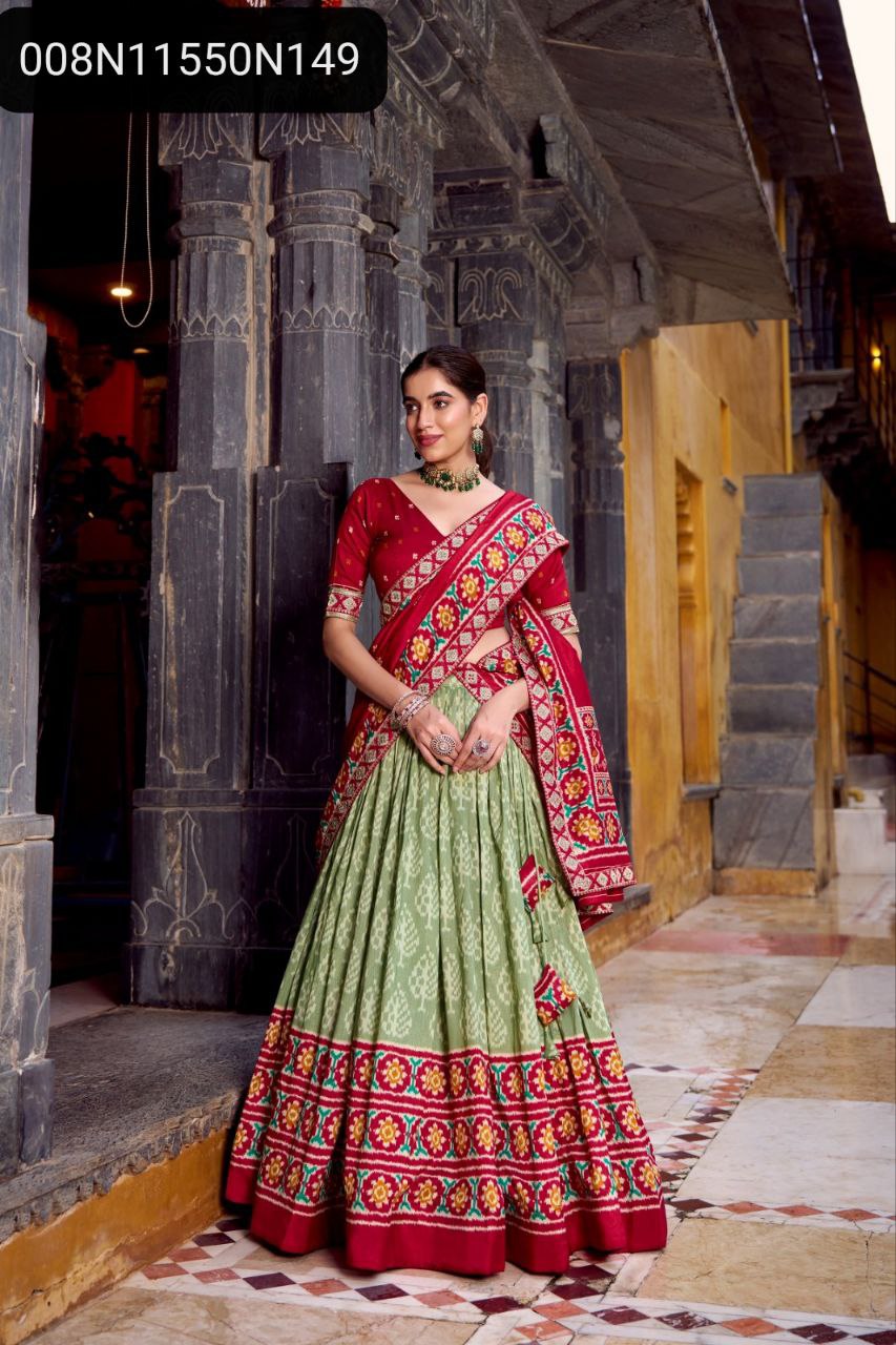 Full shot of TRENDBUY woman in Red and Sage Green Ikkat Tasar Silk Lehenga Choli, grand flair, standing in an ancient palace courtyard.