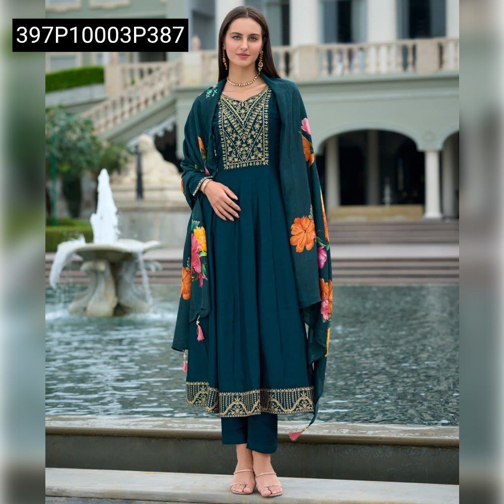 Full body shot of a model elegantly posing in the TRENDBUY Teal Vichitra Silk Anarkali Kurta Set with floral dupatta by a fountain.