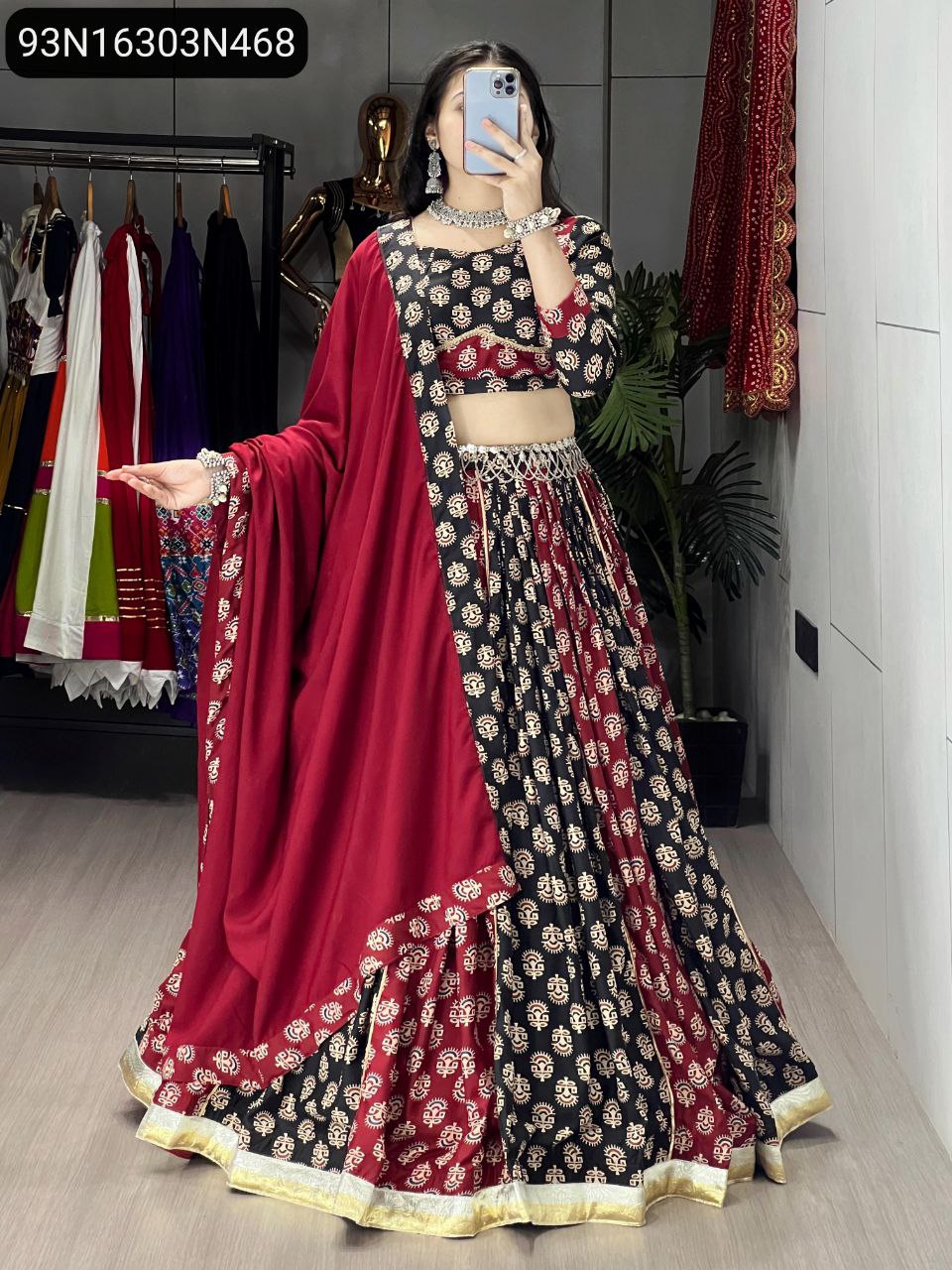 Full body front view of model showcasing a traditional black and maroon Ajarakh print lehenga choli with a wide flare and ornate gold border, ideal for festive occasions.
