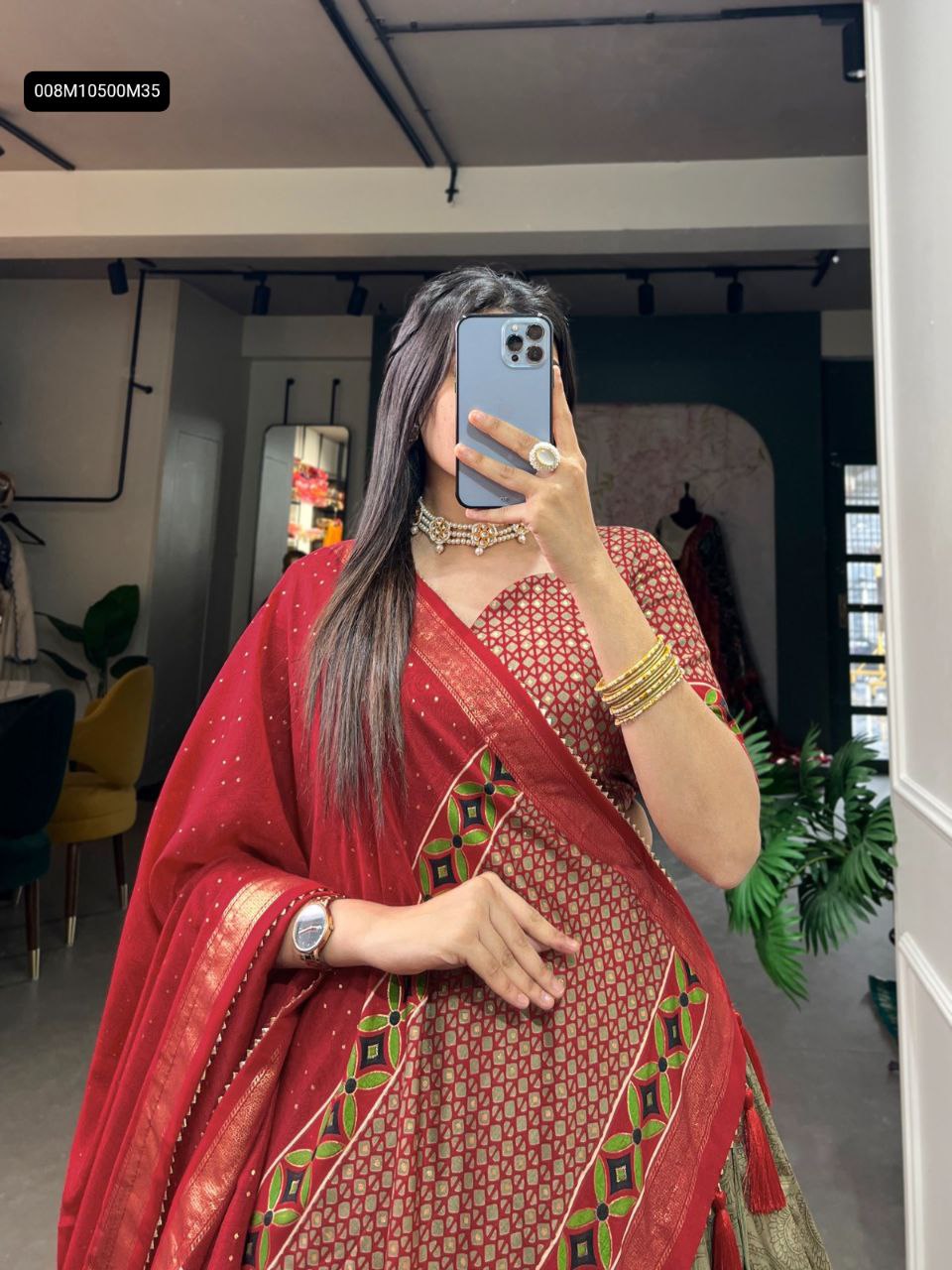 TRENDBUY Red & Olive Gold Tussar Silk Lehenga Choli, model showcasing intricate geometric and floral patterns with foil accents on the lehenga skirt and matching red blouse and dupatta, side view mirror shot.