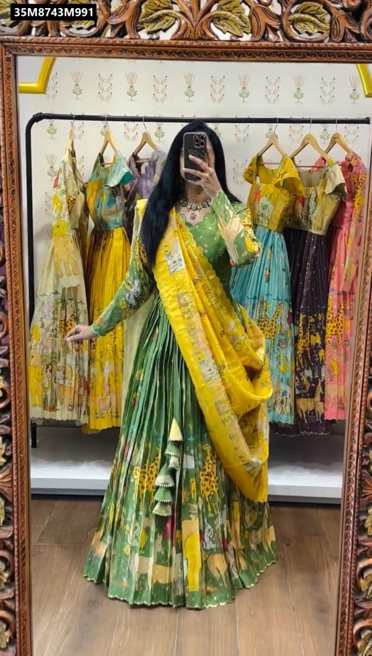 Full body shot of a woman modeling a green TRENDBUY Kalamkari print cotton lehenga choli set with a yellow dupatta, showcasing the flared skirt and intricate animal print design in a boutique setting.