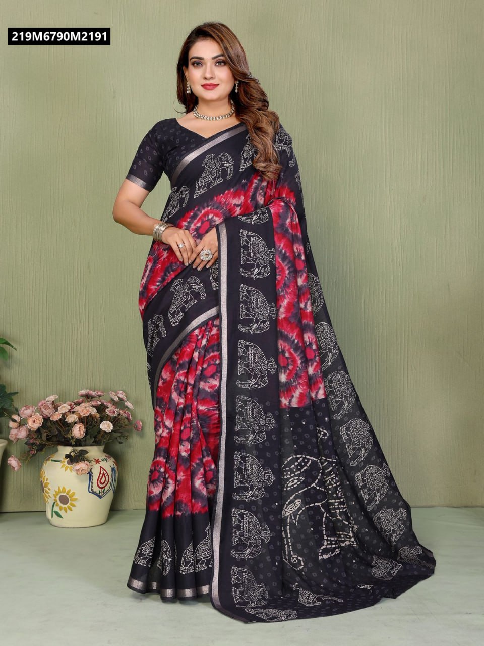 Full shot of model in black and red tie-dye Mul Cotton Kalamkari saree with elephant motifs, standing against a green wall.
