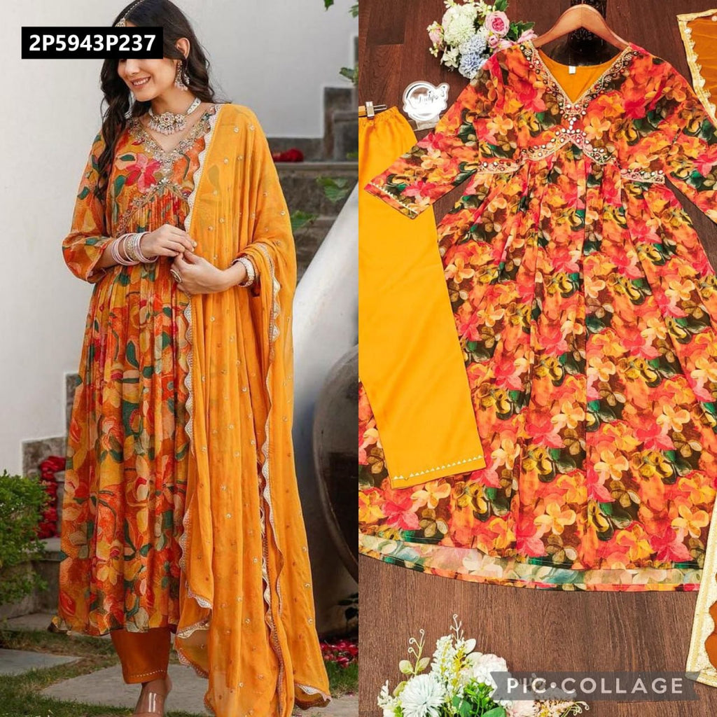TRENDBUY model gracefully posing in a vibrant orange floral digital print Fox Georgette gown set with mirror work, adorned with a flowing dupatta and matching bottoms, set against a subtle outdoor background.